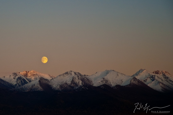 "Alaska Moon" - A full moon rises above the snow-covered mountains of Anchorage, Alaska.